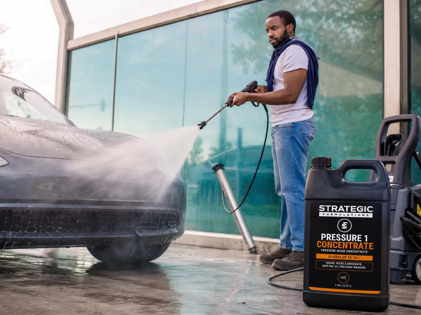 PRESSURE 1 CONCENTRATE beside a pressure washer cleaning a car outside a commercial building